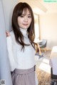 A woman leaning against a wall in a hotel room.