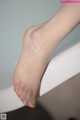 A close up of a woman's bare feet in a bathtub.