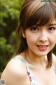 A young woman in a blue and pink dress posing for a picture.