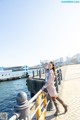 A woman standing on a pier next to the water.