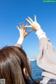 A woman reaching up to the sky with her hands.