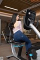 A woman sitting on a stationary bike in a gym.