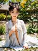 A woman in a white kimono sitting on the ground.