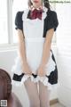 A woman in a maid outfit posing for a picture.