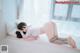 A woman laying on a bed with a pink toy.