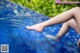 A woman's legs are submerged in a pool of water.