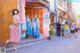 A woman wearing a face mask standing in front of a store.