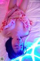 A woman laying on top of a bed covered in neon lights.