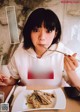 A woman sitting at a table with a plate of food.