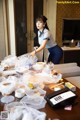 A woman in a blue skirt is preparing food on a table.