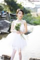 A woman in a white dress holding a bouquet of flowers.