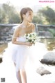 A woman in a white dress holding a bouquet of flowers.