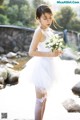 A woman in a white dress holding a bouquet of flowers.