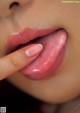 A close up of a woman's lips with her finger on her lips.