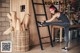 A woman sitting on a ladder in a garage.