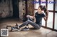 A woman sitting on the floor with a resistance band.