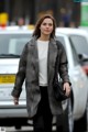 A woman walking down the street in a black and white coat.