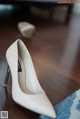 A pair of white shoes sitting on top of a wooden floor.