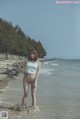 A woman standing in the water at the beach.