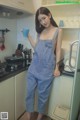 a woman standing in a kitchen holding a cup of coffee