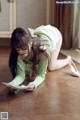 A woman laying on the floor reading a book.