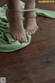 A woman's bare feet tied up on a green cloth.