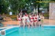 A group of women standing next to a swimming pool.