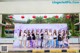 A group of women standing in front of a sign that says Sun Nature Flowers and Hot Spring Towns.