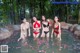 A group of women in bikinis standing in a pool of water.