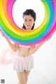 A young girl holding a rainbow ring in her hands.