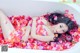 A woman laying in a bathtub covered in rose petals.