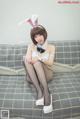 A woman in a bunny costume sitting on a couch.