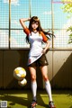 A woman in a soccer uniform holding a soccer ball.