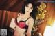 A woman in a black and red lingerie posing for a picture.