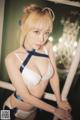 A woman in a white bra and blue lingerie posing for a picture.