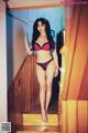 A woman in a red and black lingerie standing on a stairway.