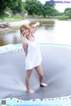 A woman in a white dress standing on a trampoline.