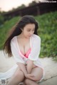 A woman in a pink bikini sitting on a beach.