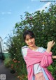 A woman in a pink and blue jacket posing for a picture.